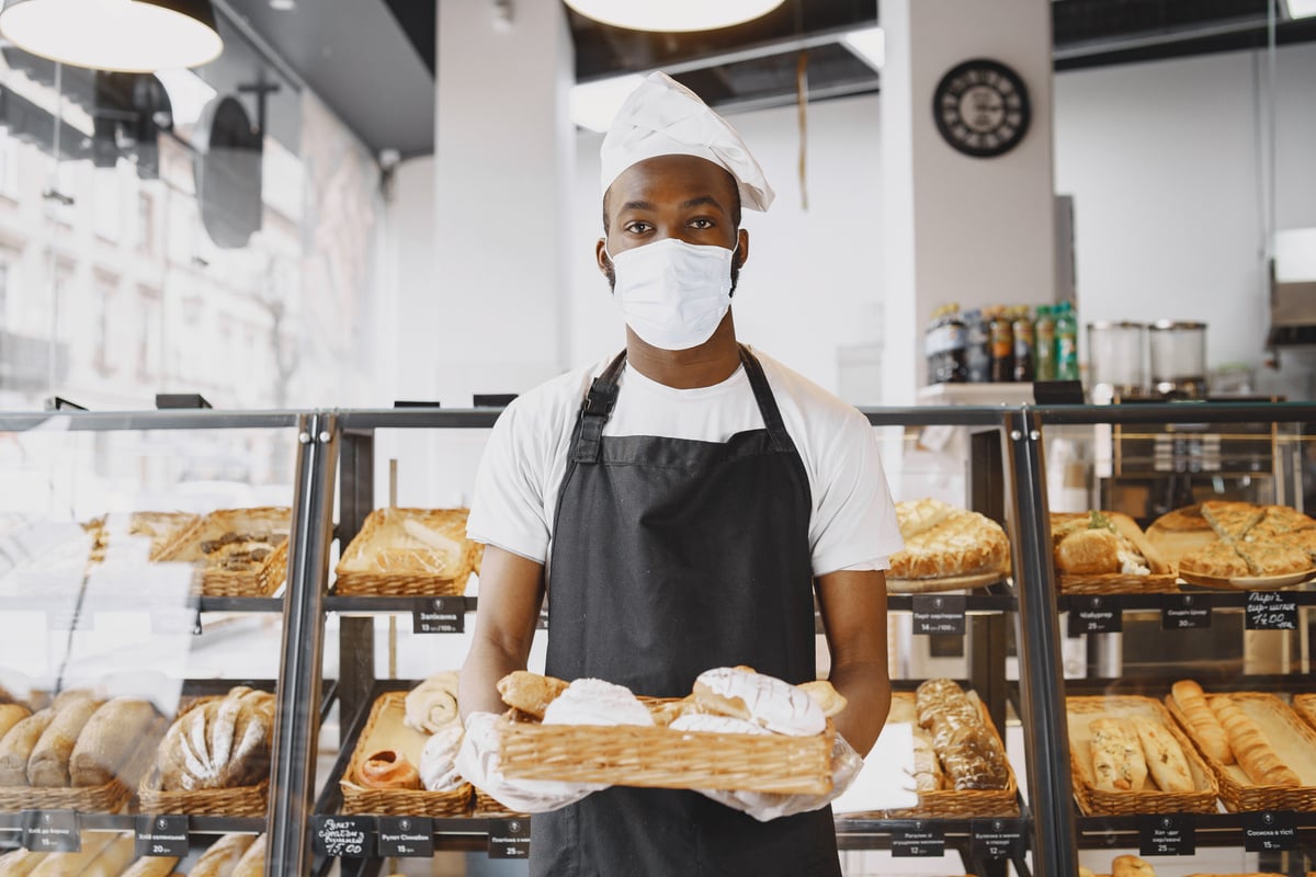 A Baker Holding a Tray with Baked Goods