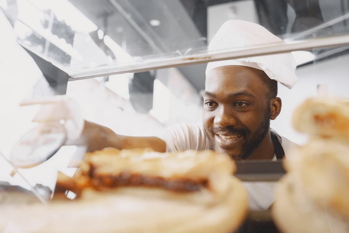 A Baker Looking Inside the Bread Display Cabinet